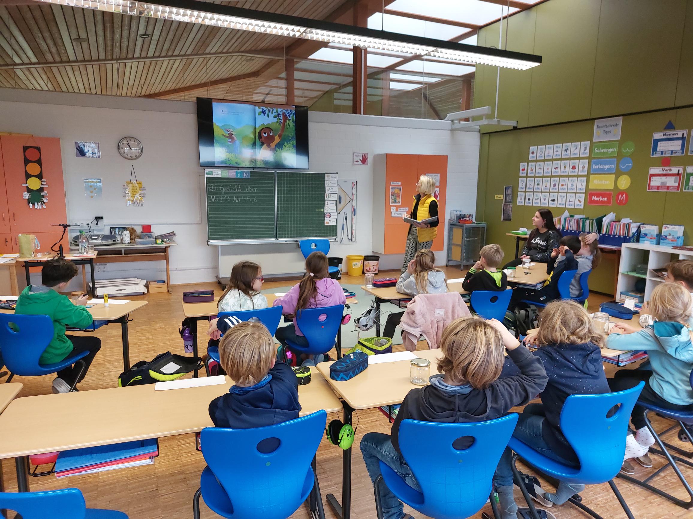 Schüler sitzen im Unterricht und blicken auf das Anzeigedisplay