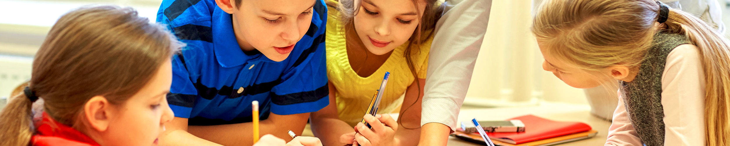 Kinder mit Stift beim gemeinsamen Schreiben
